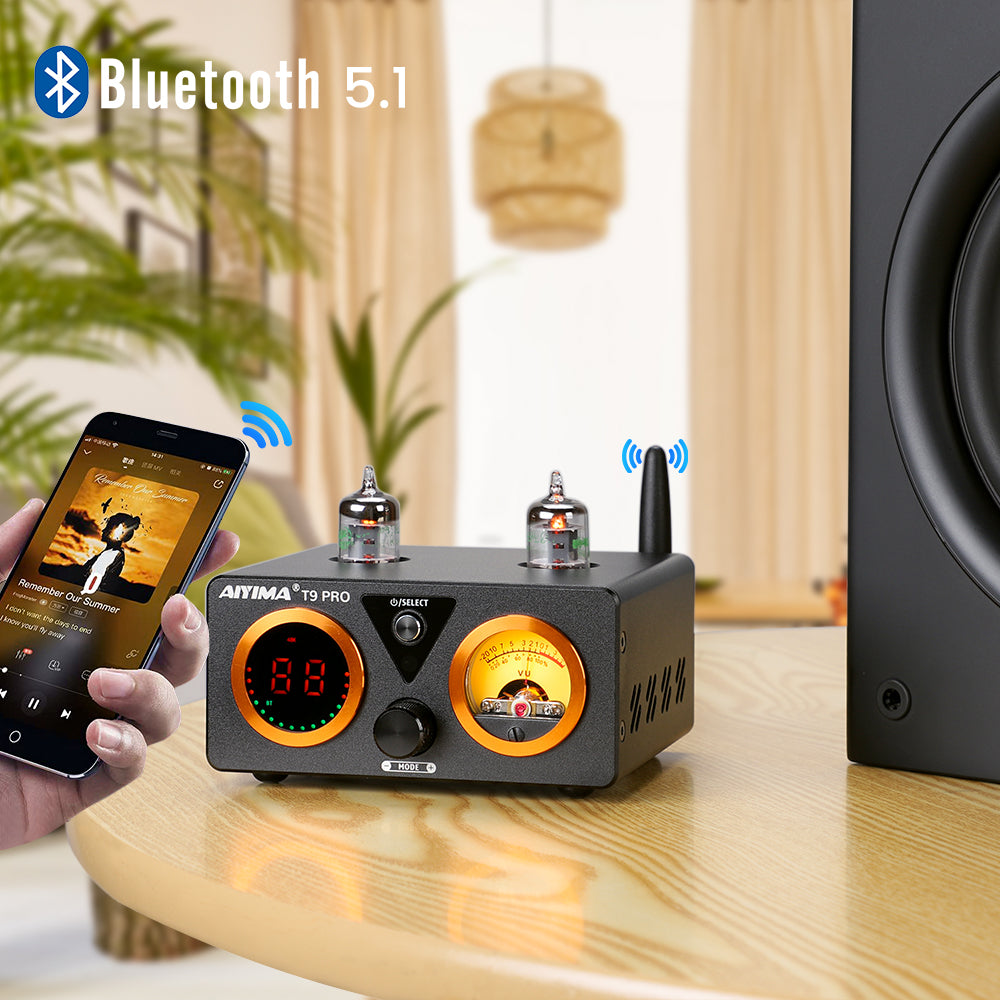 The T9 Pro on a real desk next to a subwoofer, paired over Bluetooth from a phone rather than shown as a bare studio cutout