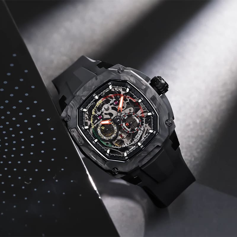 A close angled shot of the Dark Matter 1's skeleton dial and carbon-fiber bezel texture — the visible movement and cantilevered lugs are the two things photos of this watch always undersell